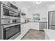 Well-lit kitchen featuring stainless steel appliances, white cabinets, and a view of the yard at 8010 Par N Ave, St Petersburg, FL 33710