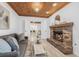 Cozy living room with brick fireplace, wood-paneled ceiling, and view to dining area at 8010 Par N Ave, St Petersburg, FL 33710