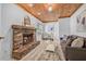 Inviting living room featuring brick fireplace, wood-paneled ceiling, and neutral décor at 8010 Par N Ave, St Petersburg, FL 33710