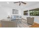Bright living room with hardwood floors, neutral decor, modern ceiling fan and natural light at 8010 Par N Ave, St Petersburg, FL 33710