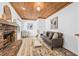 Comfortable living room with brick fireplace, wood-paneled ceiling, and classic design at 8010 Par N Ave, St Petersburg, FL 33710