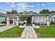Charming home featuring a quaint front porch, freshly painted exterior, and beautifully manicured landscaping at 904 E Hamilton Ave, Tampa, FL 33604