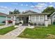 Charming home featuring a quaint front porch, freshly painted exterior, and beautifully manicured landscaping at 904 E Hamilton Ave, Tampa, FL 33604