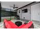 Outdoor kitchen featuring a grill, fan, television, and comfortable sofa seating at 904 E Hamilton Ave, Tampa, FL 33604