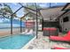 Screened-in pool area featuring a pool with beach mural, red umbrella, chaise lounges and outdoor seating at 904 E Hamilton Ave, Tampa, FL 33604