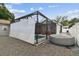 The exterior view of the screened-in pool area, hot tub, and backyard at 904 E Hamilton Ave, Tampa, FL 33604