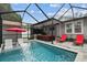 Screened-in pool featuring lounge chairs, outdoor sofa, umbrella and access to outdoor kitchen at 904 E Hamilton Ave, Tampa, FL 33604