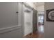 Hallway view of bathroom with gray sliding door and hardwood floors at 917 W Idlewild Ave, Tampa, FL 33604