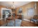 A dining room has wood floors, tan walls, modern chandelier, and is adjoined to the entry and living room at 917 W Idlewild Ave, Tampa, FL 33604