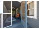 Inviting entryway porch with a decorative blue door, seating, blue painted wood and a birdcage at 917 W Idlewild Ave, Tampa, FL 33604