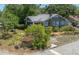 View of a quaint home featuring lush landscaping, screened front porch and a chimney at 917 W Idlewild Ave, Tampa, FL 33604