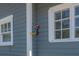 Close-up of the home's exterior with a unique bird-shaped wall decoration between two windows at 917 W Idlewild Ave, Tampa, FL 33604