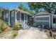 Exterior of home with charming blue paint, a detached garage, and mature landscaping at 917 W Idlewild Ave, Tampa, FL 33604