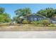 Charming single-story home with landscaped front yard featuring mature trees, plants and colorful flowers at 917 W Idlewild Ave, Tampa, FL 33604
