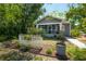 Home featuring a screened porch with tasteful furnishings, all enclosed by a charming white picket fence at 917 W Idlewild Ave, Tampa, FL 33604