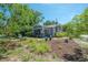 Home featuring a well-manicured front yard with flower beds and a screened porch at 917 W Idlewild Ave, Tampa, FL 33604