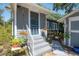 Charming home featuring a quaint front porch with colorful potted plants and a blue screen door at 917 W Idlewild Ave, Tampa, FL 33604