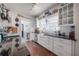 Farmhouse kitchen with white cabinets, black countertops, open shelving, white subway tile backsplash, and stainless appliances at 917 W Idlewild Ave, Tampa, FL 33604