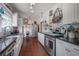 Spacious kitchen with white cabinetry, black countertops, stainless steel appliances, and decorative open shelving at 917 W Idlewild Ave, Tampa, FL 33604