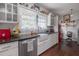 Bright kitchen with white cabinets, black counters, farmhouse sink, and open shelving for decor and storage at 917 W Idlewild Ave, Tampa, FL 33604