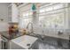 Close up on white farmhouse sink with granite countertops and white subway tile backsplash at 917 W Idlewild Ave, Tampa, FL 33604