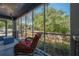 Comfortable screened porch featuring cozy furniture and views of the landscaped front yard at 917 W Idlewild Ave, Tampa, FL 33604
