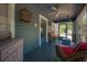 Relaxing screened porch featuring cozy furniture, blue painted wood floor and walls and a birdcage decoration at 917 W Idlewild Ave, Tampa, FL 33604