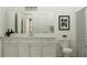 Bathroom with a double sink vanity, neutral paint, framed artwork and tiled shower with curtain at 9542 Minnow Ray Dr, Land O Lakes, FL 34638
