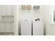 Efficient laundry room with modern washer and dryer, white cabinets, and countertop space at 9542 Minnow Ray Dr, Land O Lakes, FL 34638