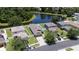 Beautiful aerial view of a home with a lake, a well-manicured lawn, and a paved driveway at 9831 Edmonton Dr, Land O Lakes, FL 34638