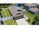 Aerial view of the home featuring a well-maintained roof, fenced yard, and nearby pond at 9831 Edmonton Dr, Land O Lakes, FL 34638