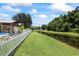 Expansive backyard with a pond view, white picket fence, and covered patio area at 9831 Edmonton Dr, Land O Lakes, FL 34638