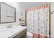 Well-lit bathroom featuring neutral décor, wood accents, a vanity with storage, and a shower/tub combo at 9831 Edmonton Dr, Land O Lakes, FL 34638