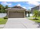 Inviting front exterior showcases a well-maintained lawn, a spacious driveway, and an attached two-car garage at 9831 Edmonton Dr, Land O Lakes, FL 34638