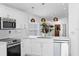 Bright kitchen with stainless steel appliances, white cabinetry, and modern pendant lighting, perfect for cooking and entertaining at 9831 Edmonton Dr, Land O Lakes, FL 34638