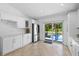 Eat-in kitchen featuring white cabinetry, stainless steel refrigerator, and sliding glass doors to the outdoor pool area at 9831 Edmonton Dr, Land O Lakes, FL 34638