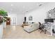 Bright and airy living room features tile flooring, comfortable seating, and a dedicated workspace with monitors at 9831 Edmonton Dr, Land O Lakes, FL 34638