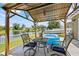 Covered patio with outdoor seating offers serene views of the pool, lake and boat dock at 9831 Edmonton Dr, Land O Lakes, FL 34638