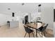 Open-concept kitchen and dining area with sleek black appliances, a waterfall island, and modern lighting at 105 12Th Sw St, Ruskin, FL 33570