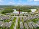 Aerial view of the community featuring a lake, woods, and an arrow pointing to the home location at 11828 Ranchers Gap Dr, Odessa, FL 33556