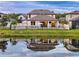Beautiful backyard and water view featuring a covered patio, furniture, and a meticulously maintained lawn at 11828 Ranchers Gap Dr, Odessa, FL 33556