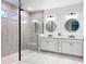 Modern bathroom with dual vanities, a spacious glass shower, and stylish lighting at 11828 Ranchers Gap Dr, Odessa, FL 33556