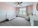 Inviting Bedroom featuring pastel pink accents, white trim, comfortable seating, and a lovely window view at 11828 Ranchers Gap Dr, Odessa, FL 33556