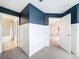 Stylish bedroom with blue accent wall, a bathroom, an extra room, plus bright white trim and plush gray carpeting at 11828 Ranchers Gap Dr, Odessa, FL 33556