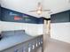 room featuring a cozy bed, spirited sports décor, white wainscoting, and an en suite bathroom access at 11828 Ranchers Gap Dr, Odessa, FL 33556