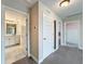 Bright hallway featuring neutral walls, plush gray carpet and white paneled doors leading to various rooms, including a bathroom at 11828 Ranchers Gap Dr, Odessa, FL 33556
