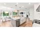 Bright kitchen features a large island with granite countertops, modern appliances, and a view to outdoor living spaces at 11828 Ranchers Gap Dr, Odessa, FL 33556