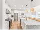 The kitchen features white cabinetry, stainless steel appliances, granite countertops, and pendant lighting over a large kitchen island at 11828 Ranchers Gap Dr, Odessa, FL 33556