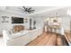 Open floorplan living room with modern ceiling fan, comfortable seating, access to kitchen, and wood-look floors at 11828 Ranchers Gap Dr, Odessa, FL 33556