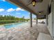 Beautiful covered patio and in-ground pool overlooking a tranquil lake, perfect for outdoor relaxation and entertainment at 11828 Ranchers Gap Dr, Odessa, FL 33556
